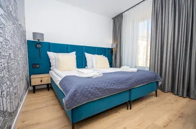 a living room with a bed and a blue couch at InPoint Kazimierz&Old Town Apartments- Free Underground Parking in Kraków