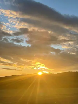 a sunset over a field with the sun in the sky at Domek z Widokiem Na Bliżniaki in Chocznia