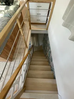 a staircase leading up to a bedroom with wooden floors at Domek z Widokiem Na Bliżniaki in Chocznia