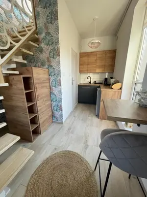 a kitchen with a staircase and a living room at Domek z Widokiem Na Bliżniaki in Chocznia