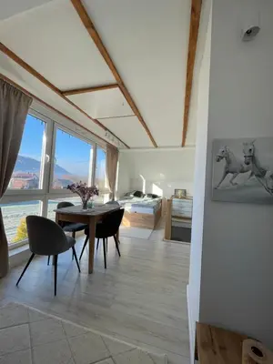 a living room with a table and chairs and a large window at Domek z Widokiem Na Bliżniaki in Chocznia