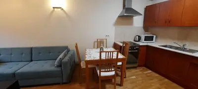 a living room with a couch and a table and a kitchen at Angel City Apartments in Kraków