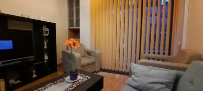 a living room with a television and a flower on a table at Angel City Apartments in Kraków