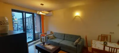 a living room with a couch and a large window at Angel City Apartments in Kraków