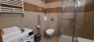 a bathroom with a shower and a toilet and a sink at Angel City Apartments in Kraków