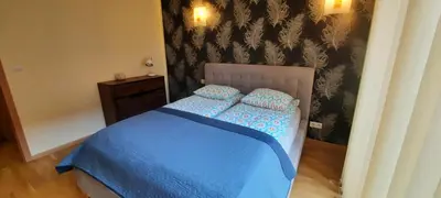a bedroom with a blue bed with two pillows at Angel City Apartments in Kraków