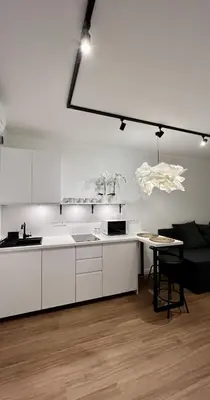 a kitchen with white cabinets and a table in a room at Way2Stay Centrum in Kraków