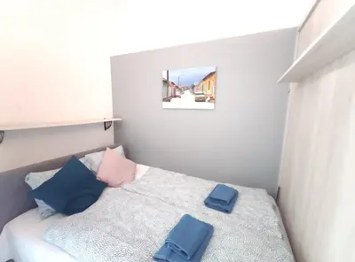 a small bedroom with a bed with blue pillows at Starowiślna 43 (C) by Homeprime in Kraków