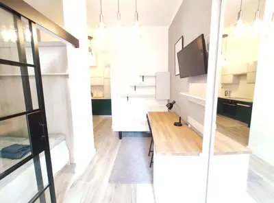 a dining room with a table and a tv at Starowiślna 43 (C) by Homeprime in Kraków