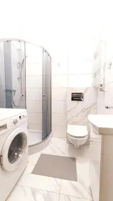 a white bathroom with a washing machine in it at Starowiślna 43 (C) by Homeprime in Kraków