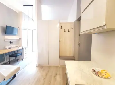 a kitchen and dining room with white cabinets and a table at Starowiślna 43 (C) by Homeprime in Kraków