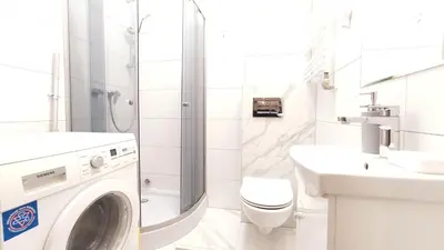 a white bathroom with a washing machine in it at Starowiślna 43 (C) by Homeprime in Kraków