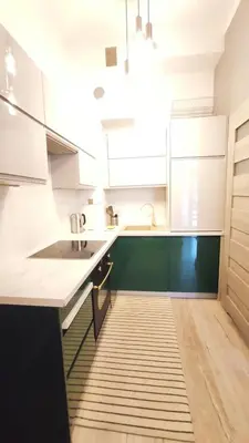 a kitchen with white cabinets and a wooden floor at Starowiślna 43 (C) by Homeprime in Kraków