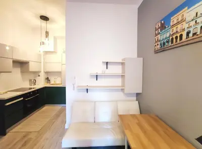 a kitchen with white cabinets and a wooden table at Starowiślna 43 (C) by Homeprime in Kraków