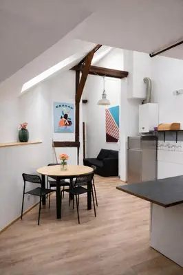 a kitchen and living room with a table and chairs at Urban Nest Apartments Augustiańska 4 in Kraków