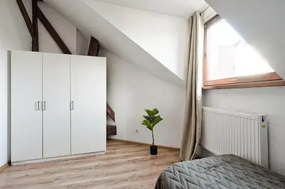 a bedroom with white cabinets and a window at Urban Nest Apartments Augustiańska 4 in Kraków