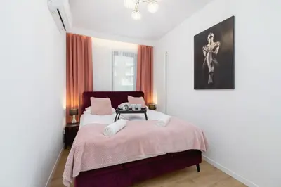 a bedroom with a bed and a table with chairs at Wiślane Tarasy Lux Apartments Cracow by Renters Prestige in Kraków