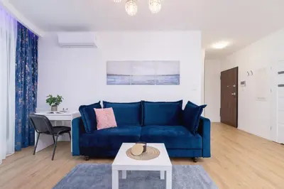 a table and chairs on a balcony with a large building at Wiślane Tarasy Lux Apartments Cracow by Renters Prestige in Kraków