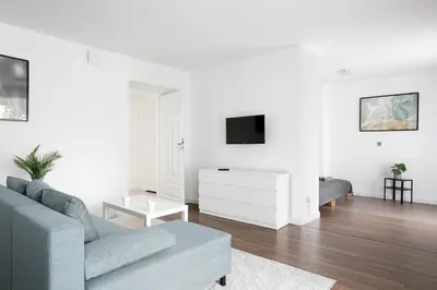 a white living room with a couch and a tv at 27Rooms Czapskich Great Location, Old Town in Kraków