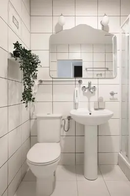 a white bathroom with a toilet and a sink at 27Rooms Czapskich Great Location, Old Town in Kraków