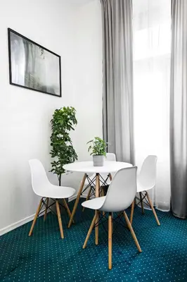 a dining room with a table and chairs and a plant at 27Rooms Czapskich Great Location, Old Town in Kraków
