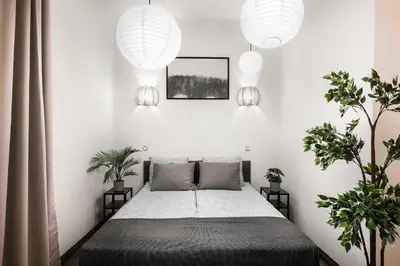 a bedroom with a bed and two potted plants at 27Rooms Czapskich Great Location, Old Town in Kraków