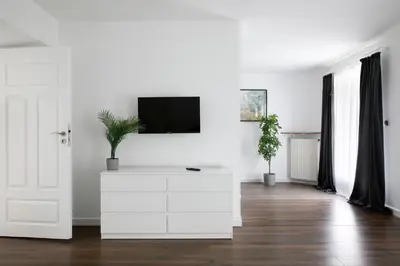 a white living room with a tv on a white wall at 27Rooms Czapskich Great Location, Old Town in Kraków