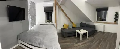 a bedroom with a large bed and a table at Apartament Bronowice in Kraków