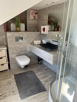 a bedroom with a bed and a desk and a tv at Apartament Bronowice in Kraków
