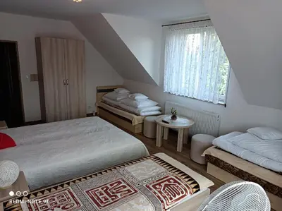 a bedroom with two beds and a window at Dom Wakacyjny Gajówka z ogrodem i jacuzzi do stoku 2km in Rzyki
