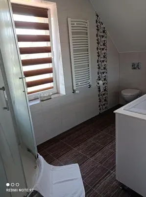 a bathroom with a shower and a toilet and a sink at Dom Wakacyjny Gajówka z ogrodem i jacuzzi do stoku 2km in Rzyki