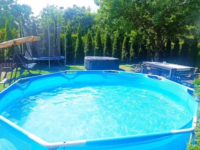 a large pool of water in a yard at Dom Wakacyjny Gajówka z ogrodem i jacuzzi do stoku 2km in Rzyki