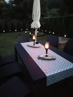 a table with two candles on it with an umbrella at Dom Wakacyjny Gajówka z ogrodem i jacuzzi do stoku 2km in Rzyki