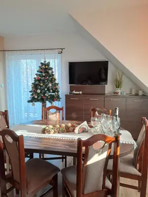 a dining room with a table and a christmas tree at Dom Wakacyjny Gajówka z ogrodem i jacuzzi do stoku 2km in Rzyki