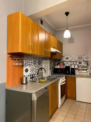 a kitchen with wooden cabinets and a counter top at REAL Hostel in Kraków