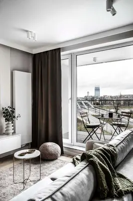 a living room with a couch and a large window at Apartment Premium with Parking, Air Condition and balcony in Kraków