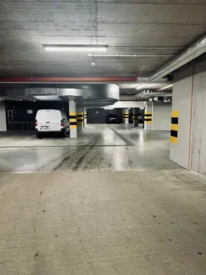 an empty parking garage with a white van parked in it at Apartment Premium with Parking, Air Condition and balcony in Kraków