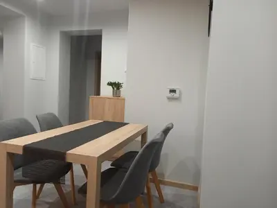 a dining room with a wooden table and chairs at Apartament na Słonecznej in Łączany