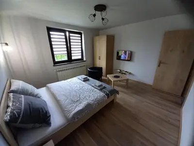 a bedroom with a bed and a window and a table at Apartament na Słonecznej in Łączany