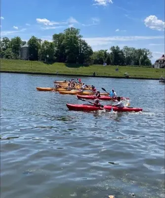 a group of people in red kayaks on a lake at Apartament na Słonecznej in Łączany