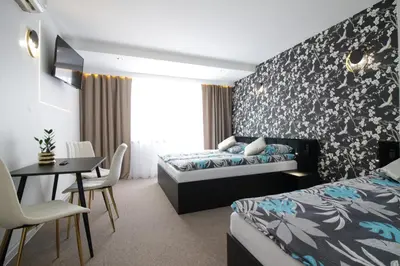a hotel room with two beds and a table and chairs at Motel Na Zbójeckiej in Skawa