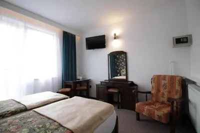 a hotel room with a bed and a chair and a mirror at Motel Na Zbójeckiej in Skawa