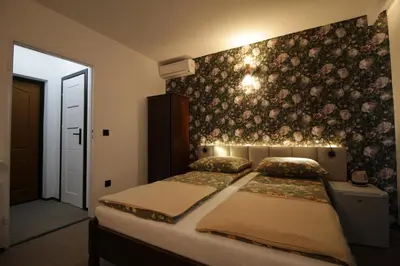 a bedroom with a bed and a wall with flowers at Motel Na Zbójeckiej in Skawa