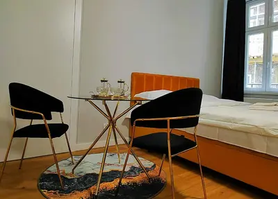 a bedroom with a table and two chairs and a bed at Hugo Star Apartments in Kraków