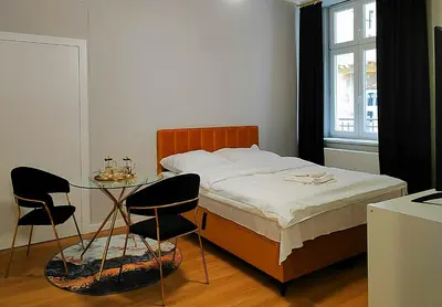 a bedroom with a bed and a table and chairs at Hugo Star Apartments in Kraków