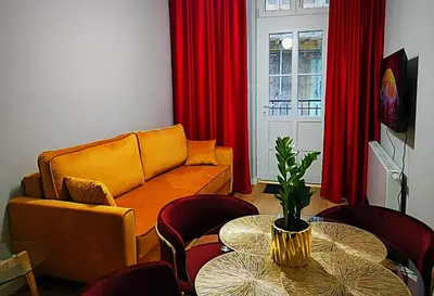 a living room with a couch and a table with chairs at Hugo Star Apartments in Kraków