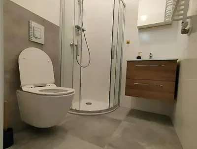 a bathroom with a toilet and a glass shower at Hugo Star Apartments in Kraków