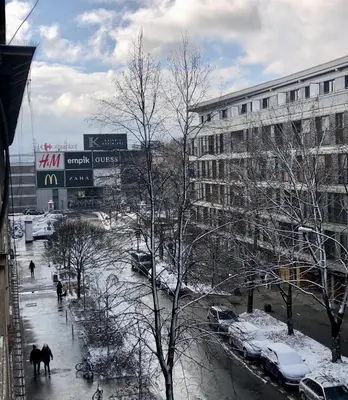 a city street with snow covered cars and buildings at Time for Cracow in Kraków
