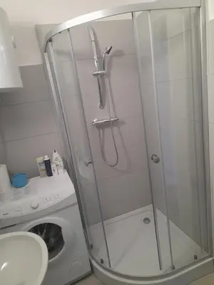 a shower stall in a bathroom with a washing machine at Time for Cracow in Kraków