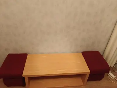 a wooden bench with two red cushions on it at Time for Cracow in Kraków